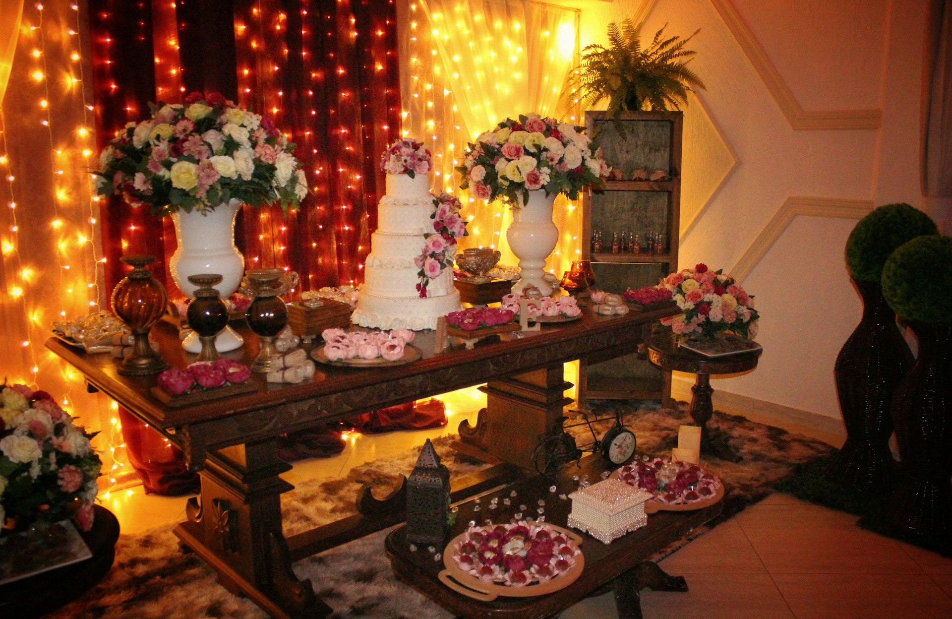 a table topped with lots of cakes and flowers